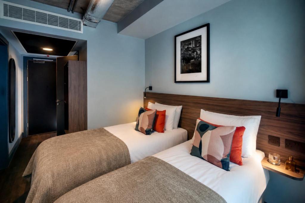 Twin beds in a private room, with a walnut headboard