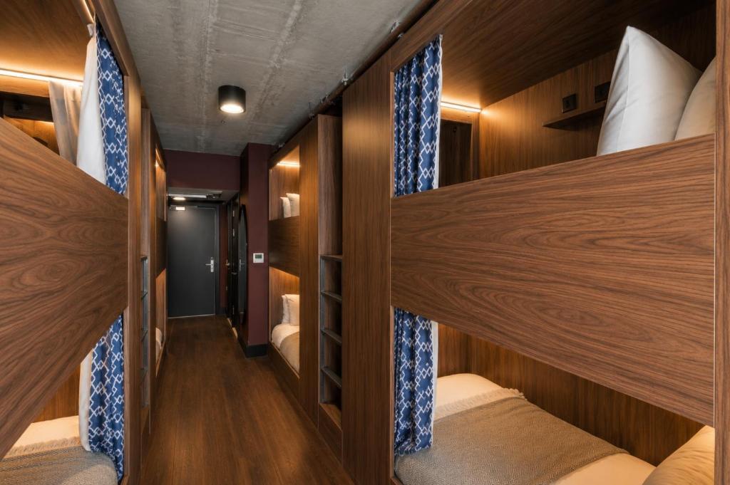 Pod beds along a shared dorm corridor